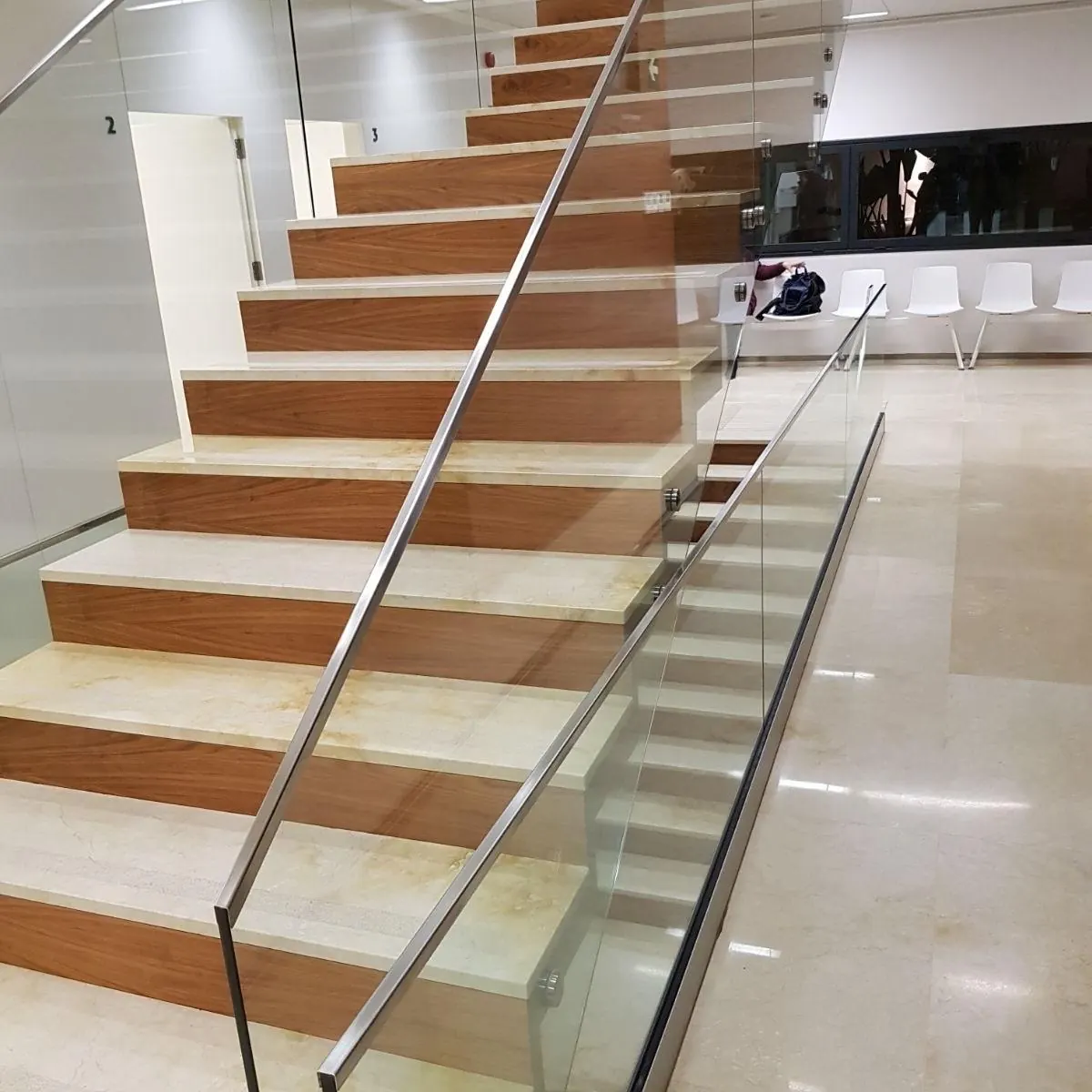 Escalera con barandilla de vidrio y pasamanos de acero inoxidable