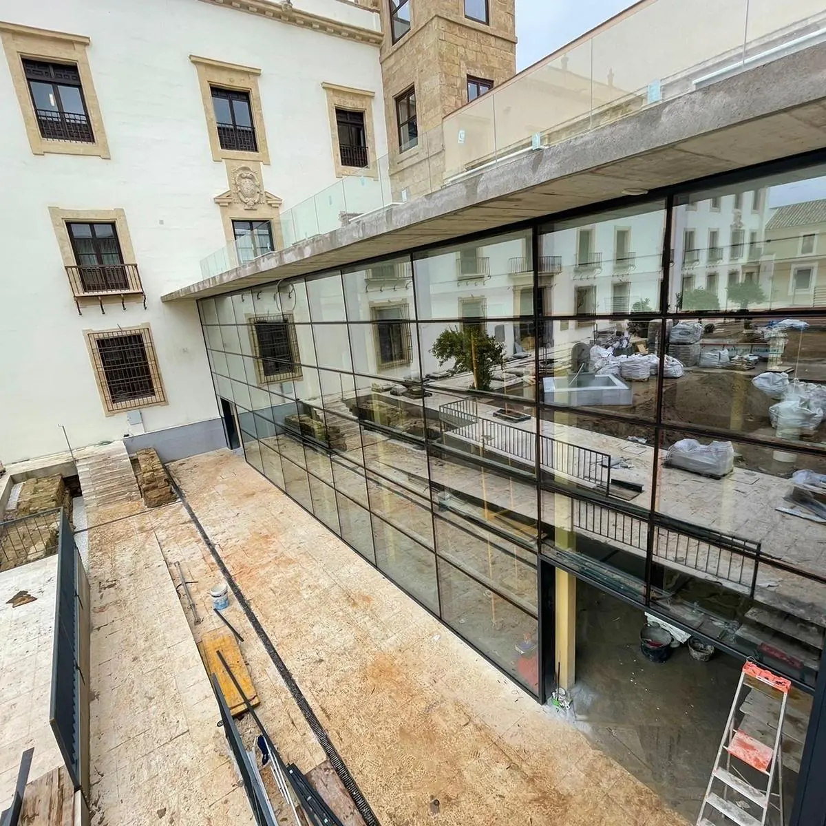 Fachada acristalada continua junto a edificio histórico
