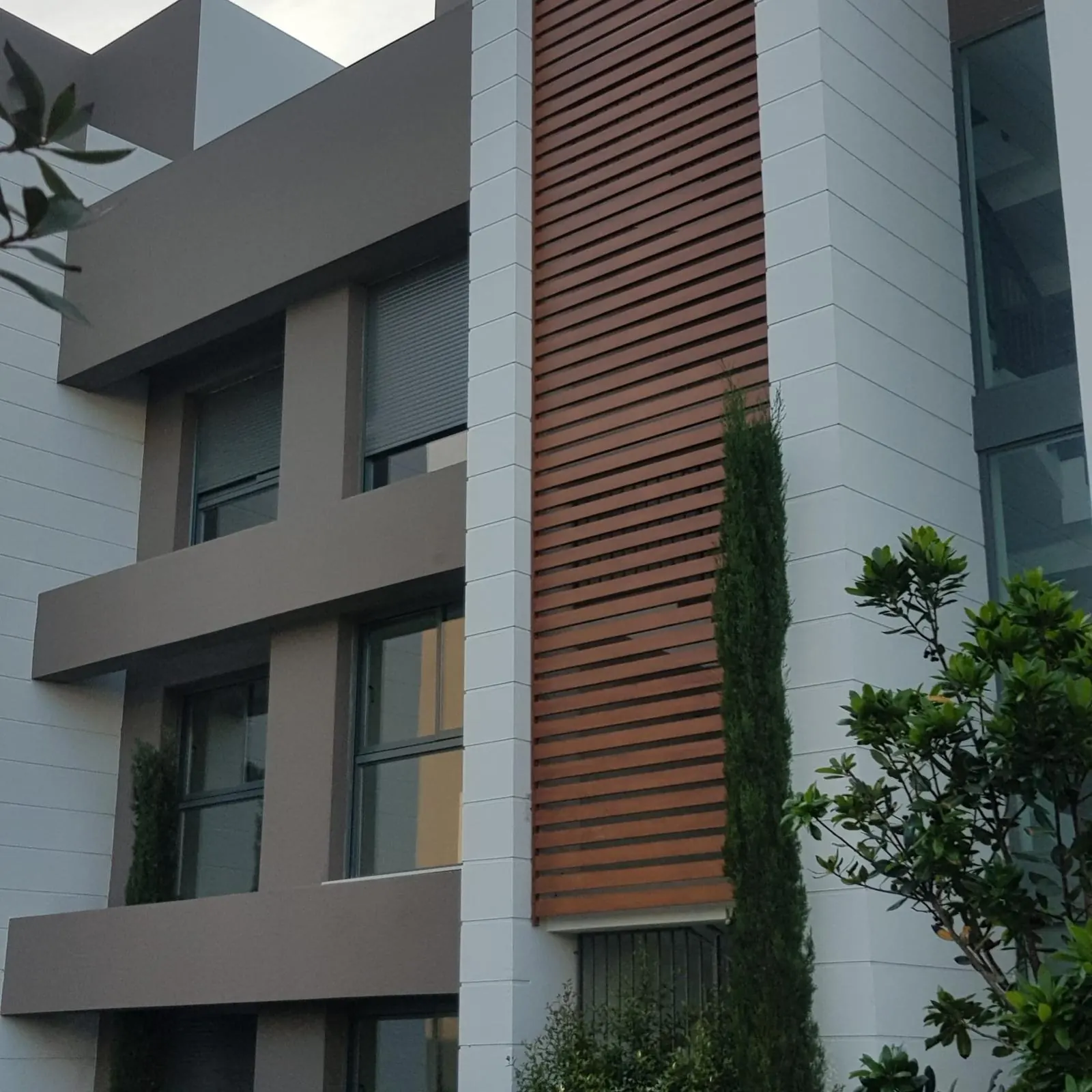 Fachada con volúmenes revestidos de composite gris