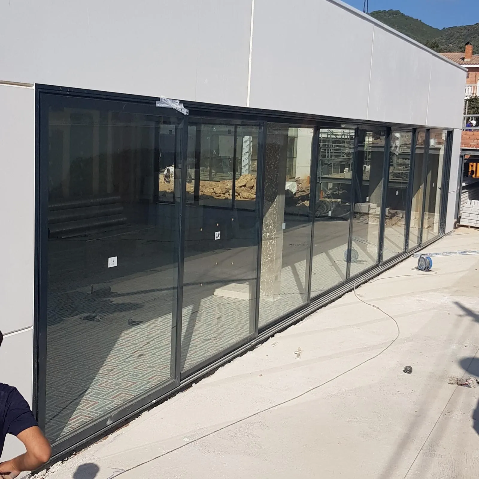 Cerramiento corredero de aluminio negro en planta baja durante la instalación