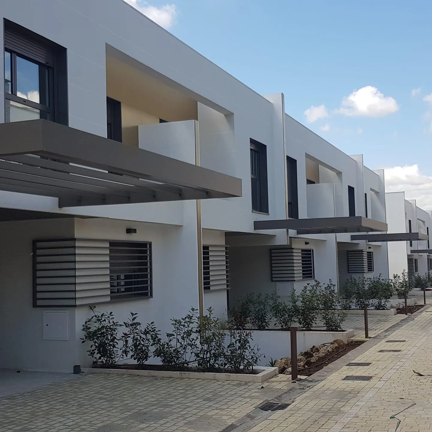 Viviendas adosadas con celosías y ventanas de aluminio