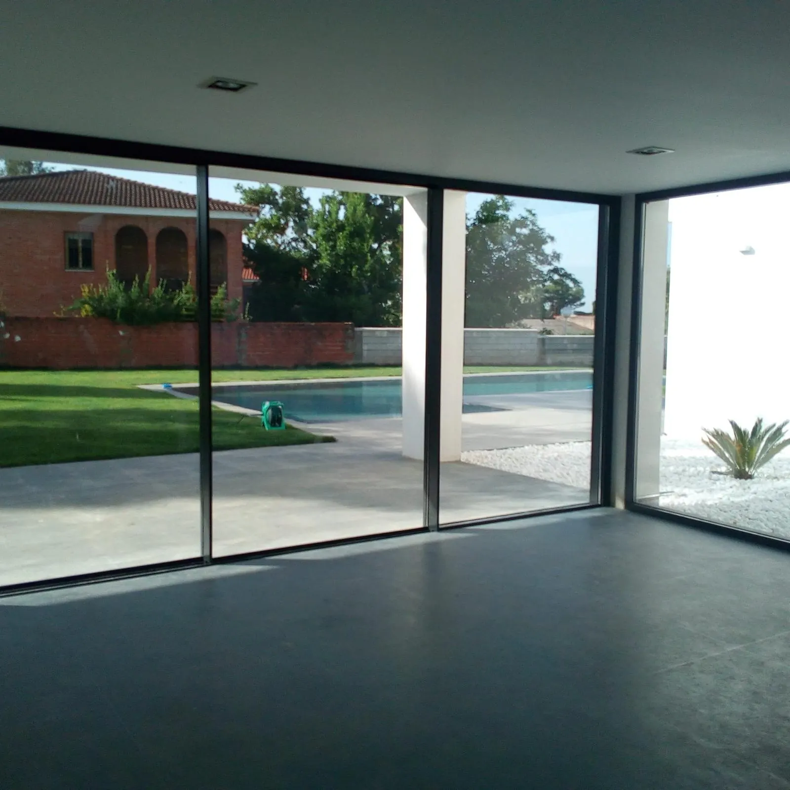 Esquina acristalada con correderas de aluminio frente a la piscina