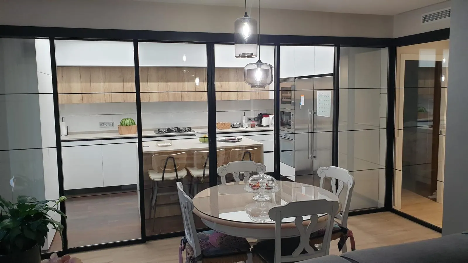 Cocina cerrada con carpintería de aluminio negro estilo industrial