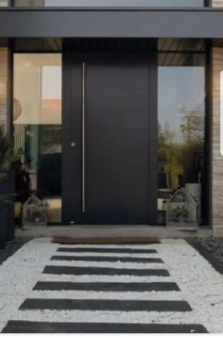 Puerta de entrada de aluminio negro con tirador vertical