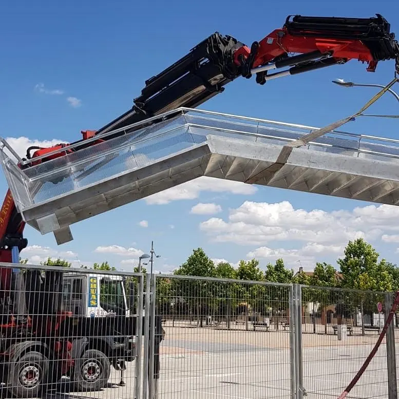 Grúa colocando una estructura de aluminio y vidrio en obra