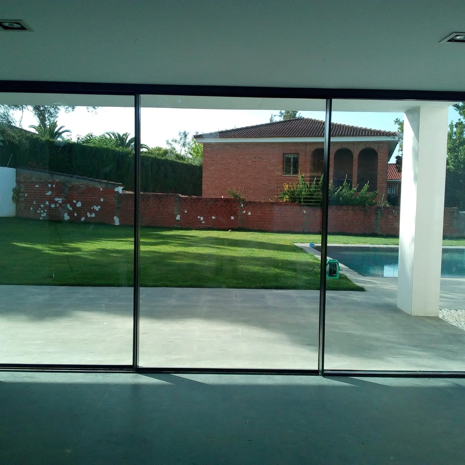 Corredera de aluminio de gran formato frente a la piscina