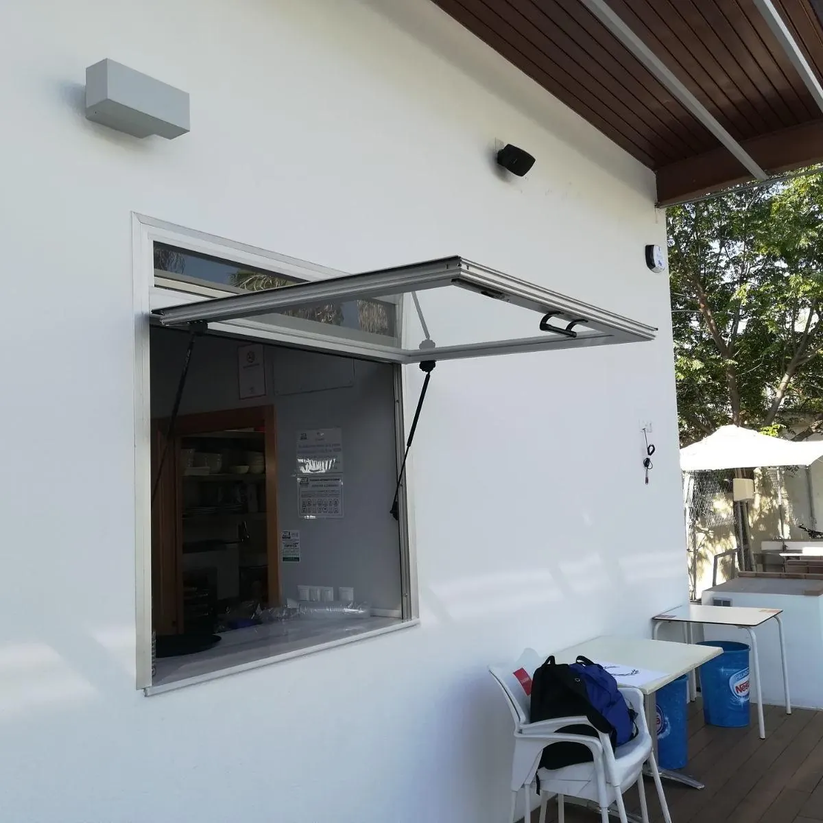 Ventana abatible de aluminio en fachada blanca