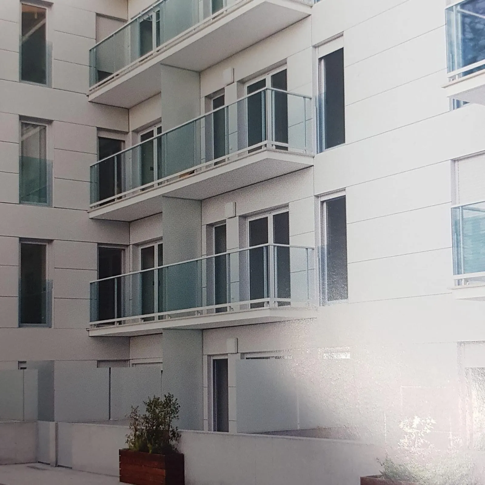 Edificio de viviendas con barandillas de vidrio y ventanas de aluminio