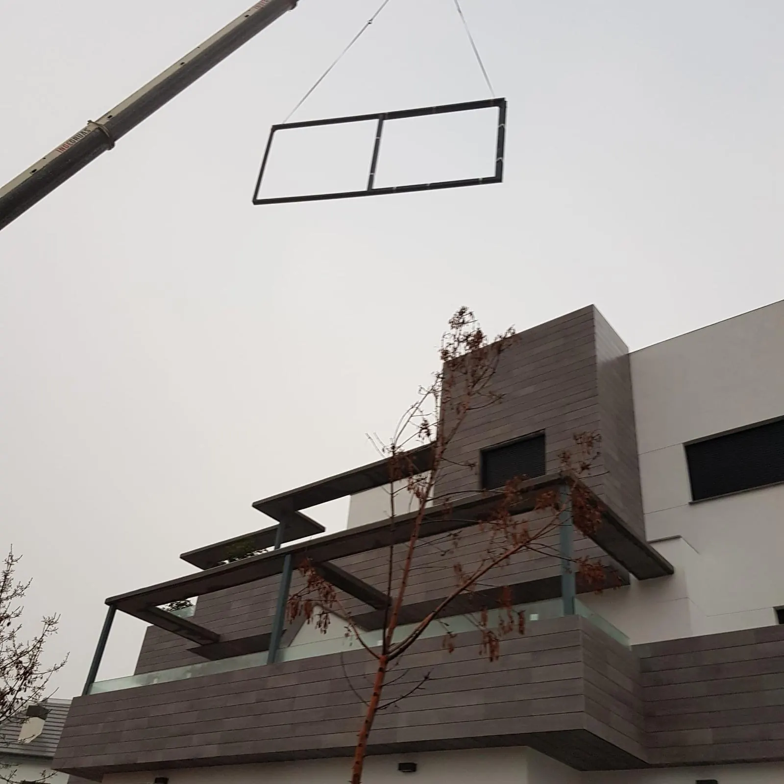Voladizo de vidrio y aluminio en fachada visto desde abajo
