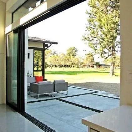 Puerta corredera de aluminio negro abierta al jardín