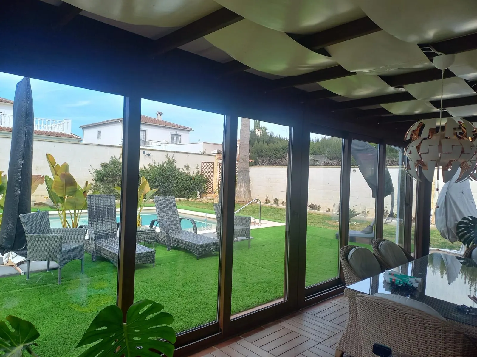 Cerramiento de porche de PVC imitación madera con vistas al jardín
