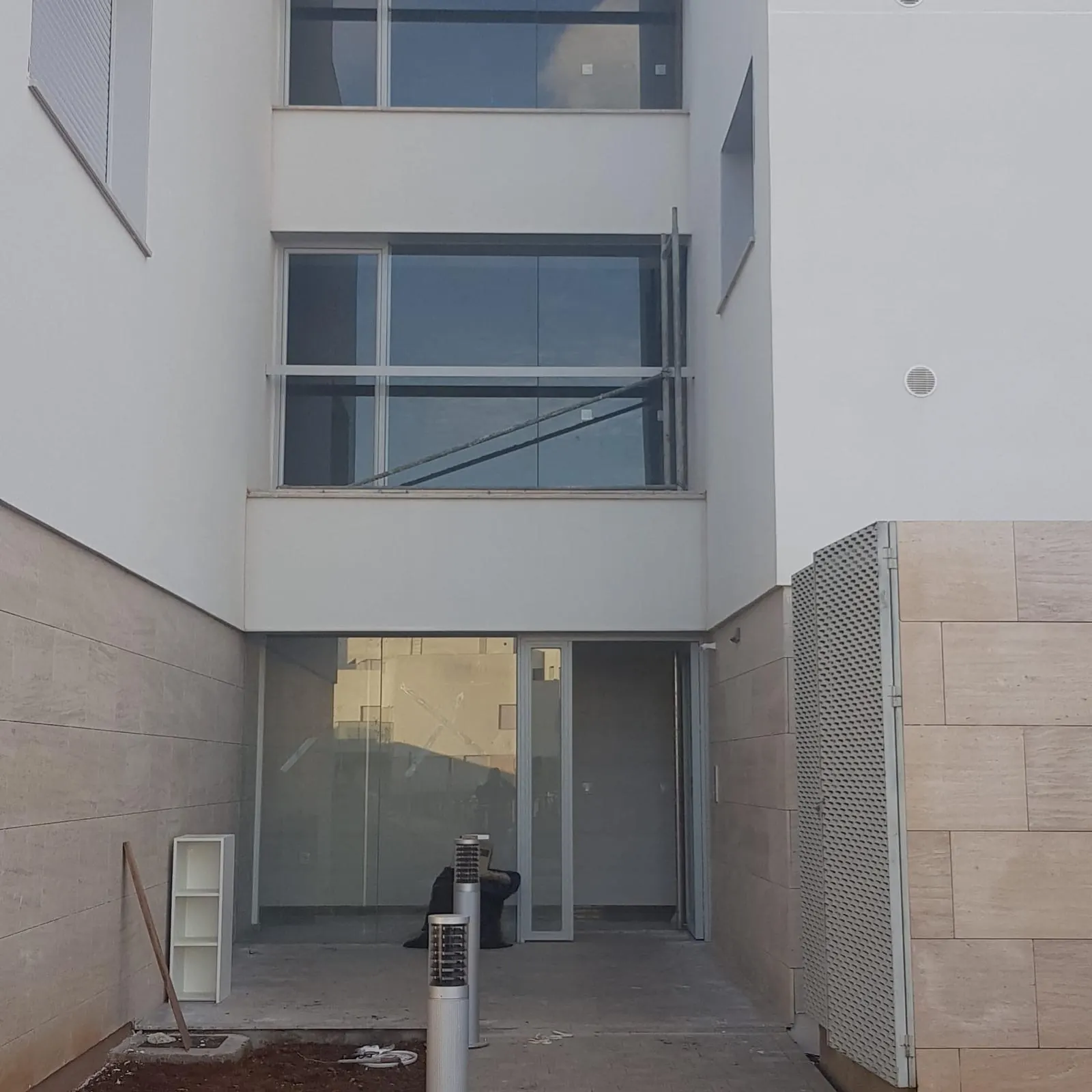 Fachada con ventanas y puerta de entrada acristalada