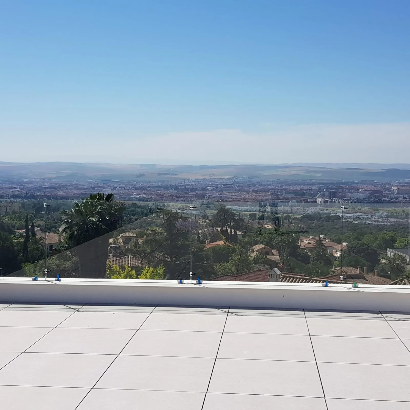 Terraza con barandilla de vidrio y vistas a la ciudad