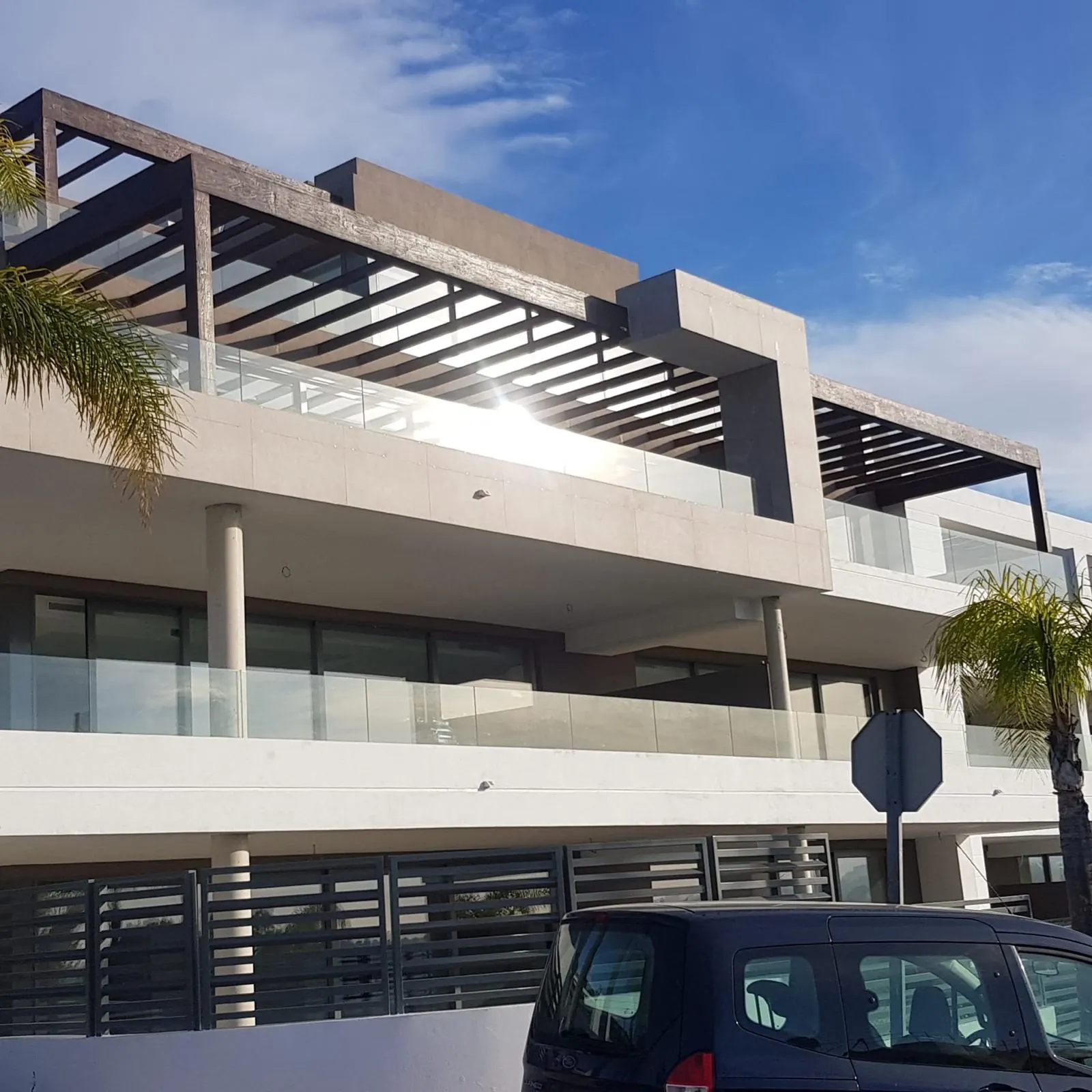 Edificio con barandillas de vidrio y pérgolas